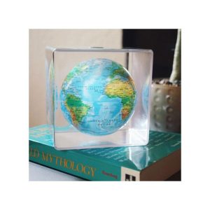 Mova Globe Relief Map Cube auf einem Buch liegend