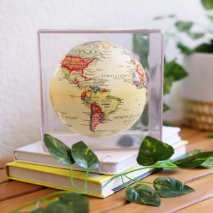 Mova Globe Yellow Political Cute auf einem Buch liegend